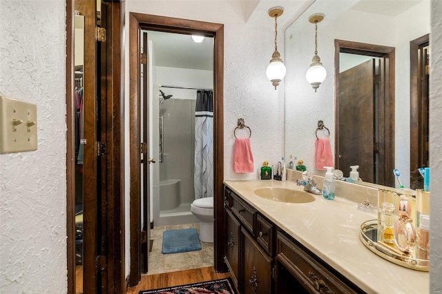 full bath featuring vanity, toilet, a shower with curtain, and a textured wall