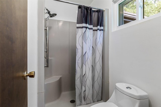 bathroom featuring curtained shower and toilet