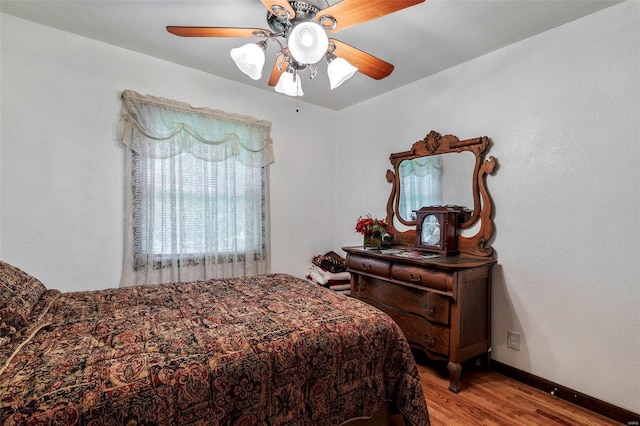 bedroom with baseboards, wood finished floors, and a ceiling fan