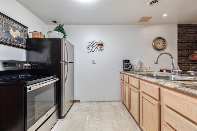 kitchen with stainless steel electric range oven, light brown cabinets, visible vents, and a sink