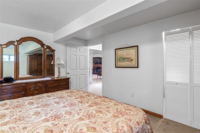 bedroom with baseboards and light carpet