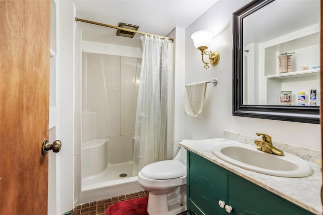 full bathroom featuring vanity, a shower stall, and toilet