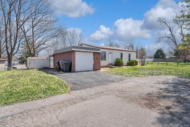 view of front of home with aphalt driveway, an attached garage, fence, and a front lawn