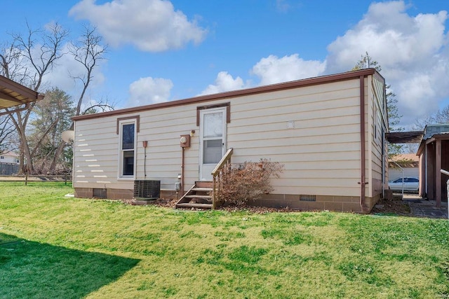 rear view of property featuring crawl space, entry steps, and a yard