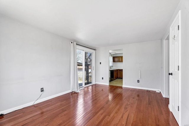 unfurnished living room with baseboards and hardwood / wood-style floors