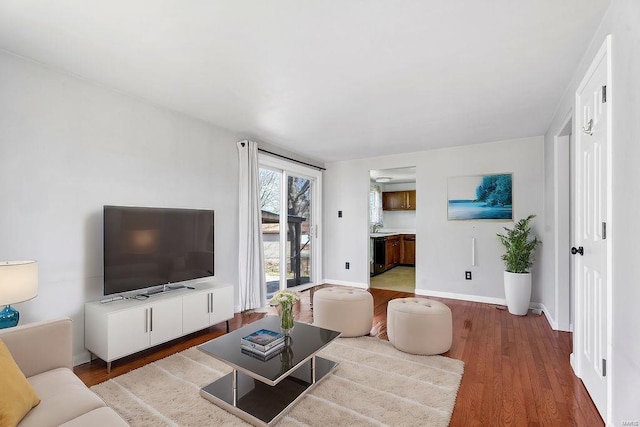 living area featuring baseboards and wood finished floors