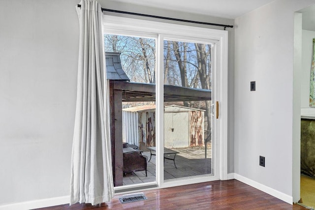 doorway to outside with visible vents, baseboards, and wood finished floors