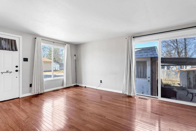 interior space with visible vents, wood-type flooring, and baseboards