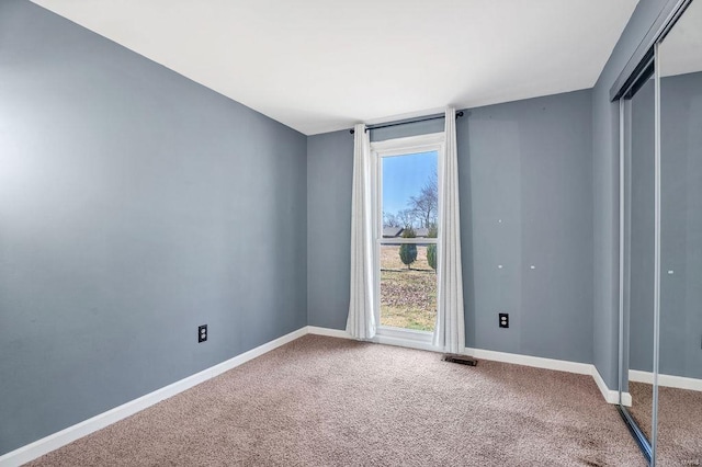 empty room with visible vents, baseboards, and carpet