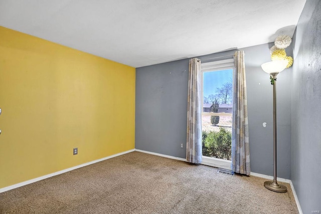 carpeted empty room with baseboards and visible vents