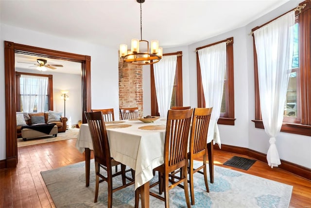 dining room with a chandelier, visible vents, baseboards, and wood-type flooring