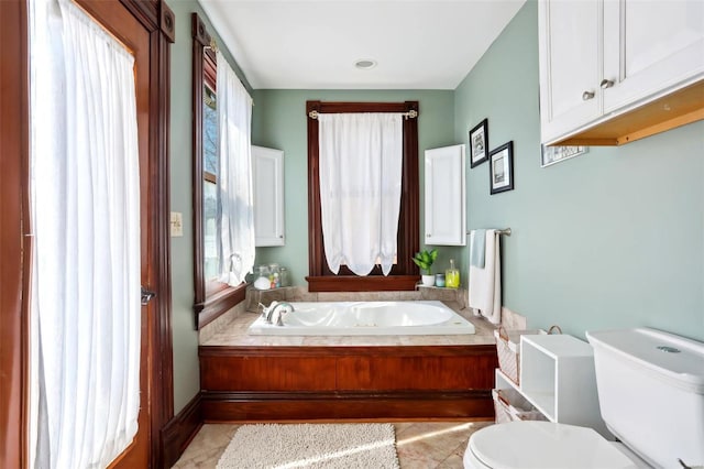 full bath featuring a garden tub, toilet, and tile patterned flooring