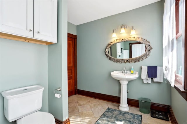 bathroom with toilet and baseboards