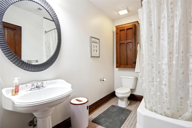 full bath with tile patterned floors, shower / bath combination with curtain, toilet, and baseboards