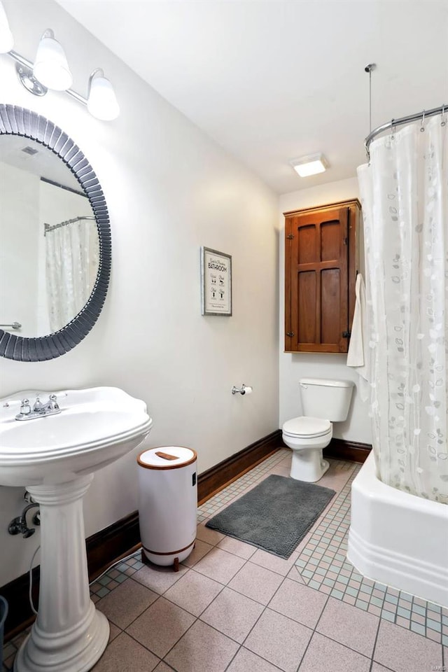 full bathroom featuring tile patterned floors, toilet, shower / bath combo, and baseboards