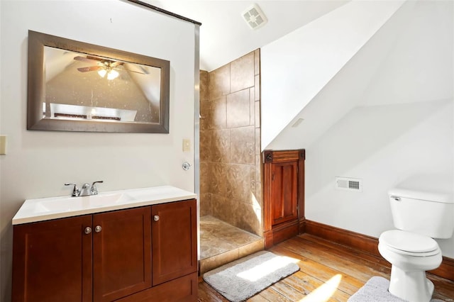 full bath featuring wood finished floors, visible vents, tiled shower, ceiling fan, and toilet