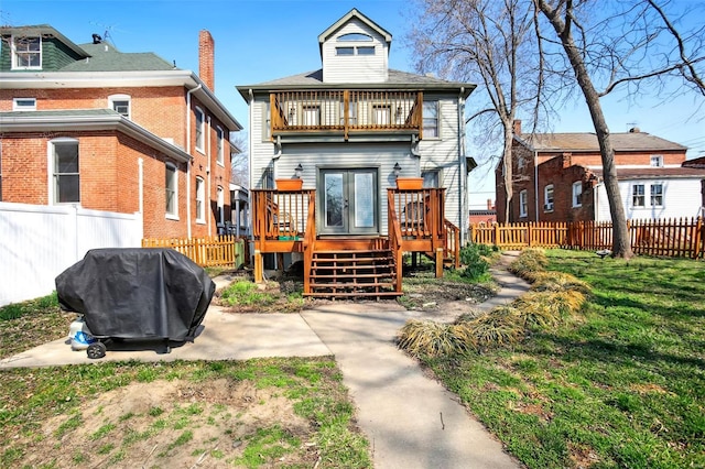 rear view of house featuring a balcony, fence private yard, and a wooden deck