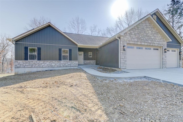 single story home featuring stone siding, board and batten siding, concrete driveway, and an attached garage