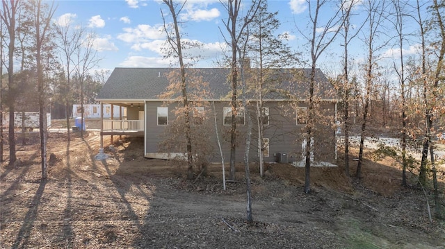 rear view of property featuring roof with shingles