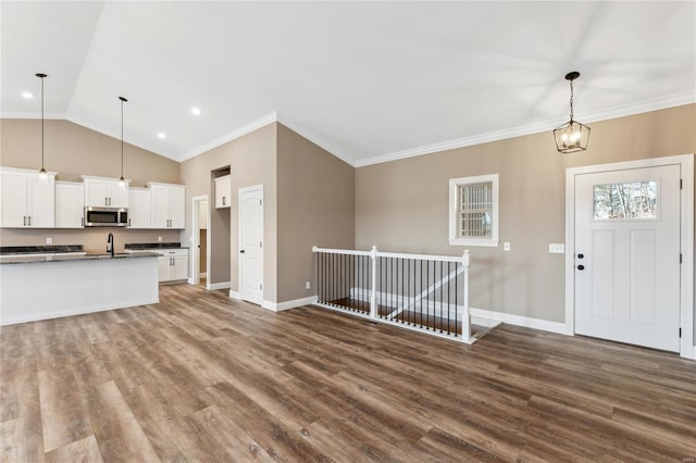 interior space with crown molding, wood finished floors, baseboards, and lofted ceiling