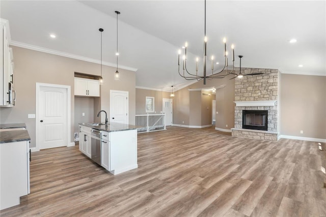 kitchen featuring light wood finished floors, a sink, ornamental molding, stainless steel appliances, and white cabinetry