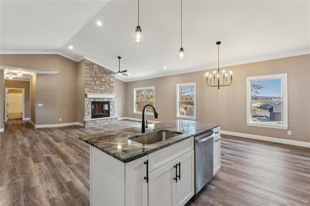 kitchen featuring a sink, a fireplace, crown molding, lofted ceiling, and dishwasher