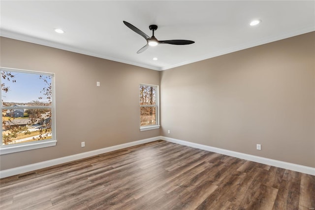 unfurnished room with wood finished floors, a ceiling fan, visible vents, baseboards, and crown molding