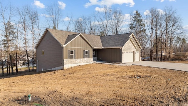 view of front of house featuring stone siding, an attached garage, and concrete driveway