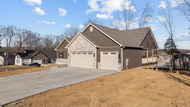 view of side of home featuring a garage, stone siding, driveway, and a shingled roof