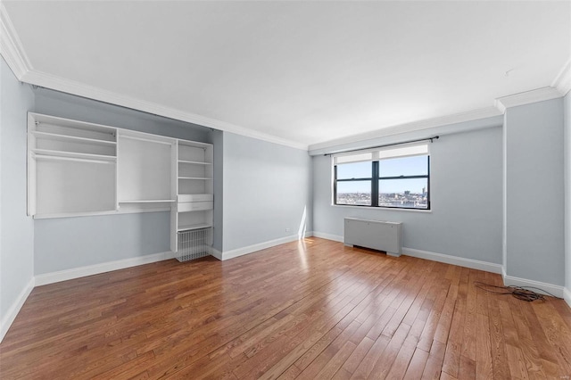 unfurnished bedroom featuring hardwood / wood-style floors, radiator, baseboards, and ornamental molding