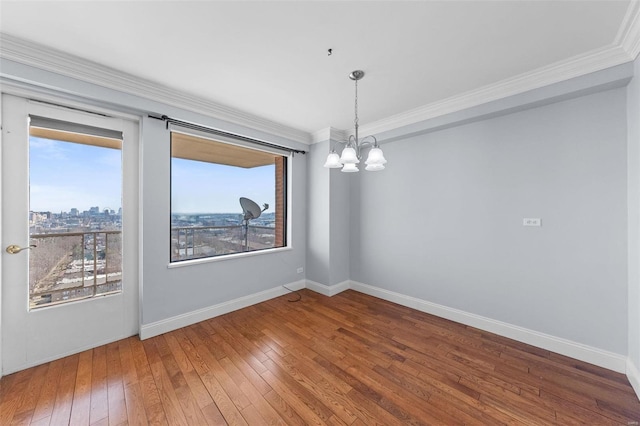 empty room with ornamental molding, baseboards, and hardwood / wood-style floors