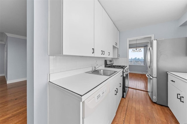 kitchen with white cabinets, appliances with stainless steel finishes, light countertops, and a sink