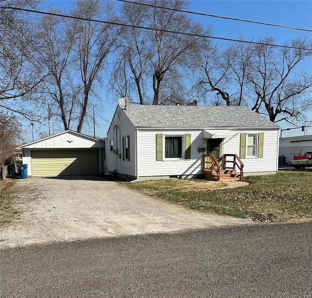 view of front of house featuring an outbuilding, crawl space, a detached garage, and roof with shingles