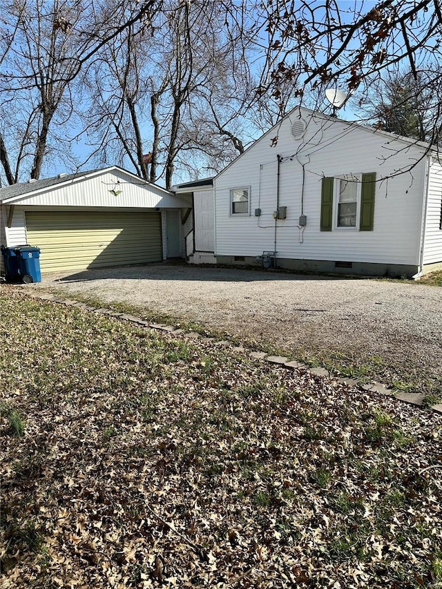 view of property exterior with crawl space, a garage, and driveway