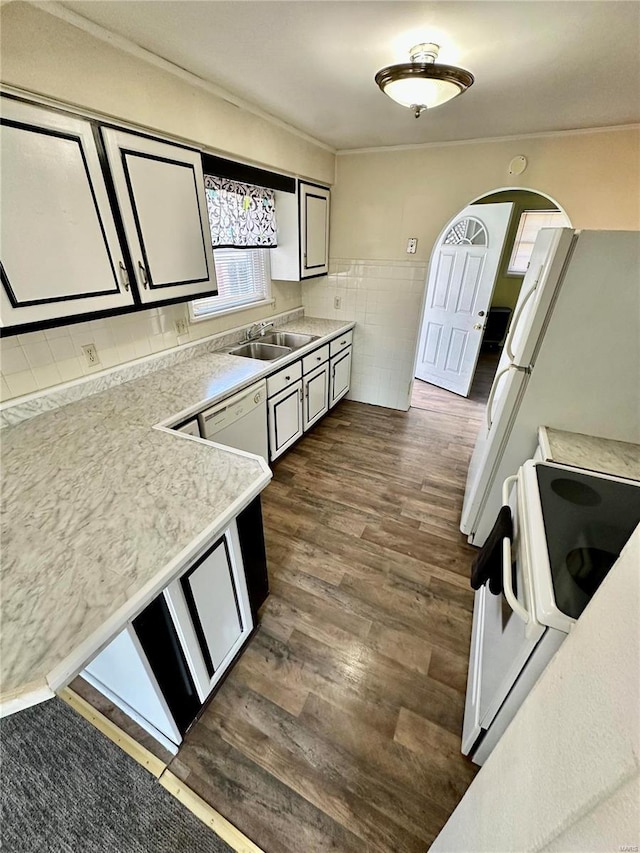 kitchen with electric range, a sink, dark wood finished floors, tile walls, and light countertops