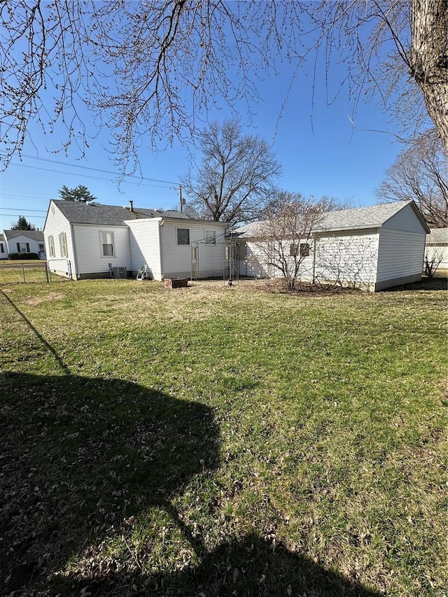 view of yard featuring an outdoor structure and fence