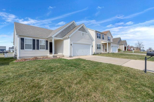 view of front facade featuring a front yard, concrete driveway, and a garage