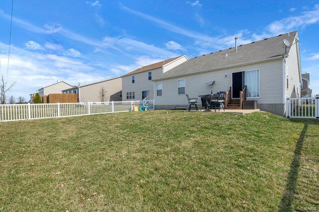 rear view of house featuring a patio area, a lawn, entry steps, and a fenced backyard