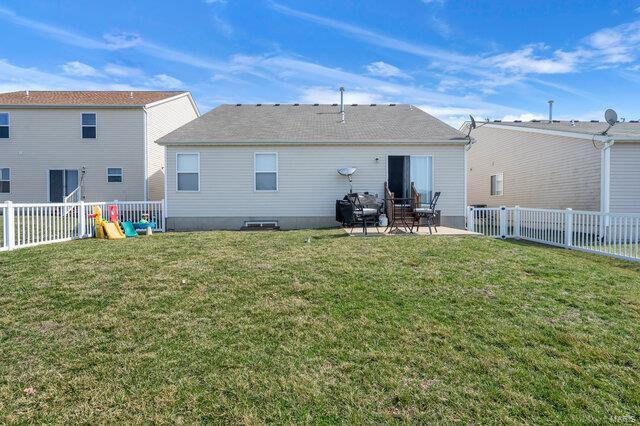 back of property with a playground, a yard, and a patio area