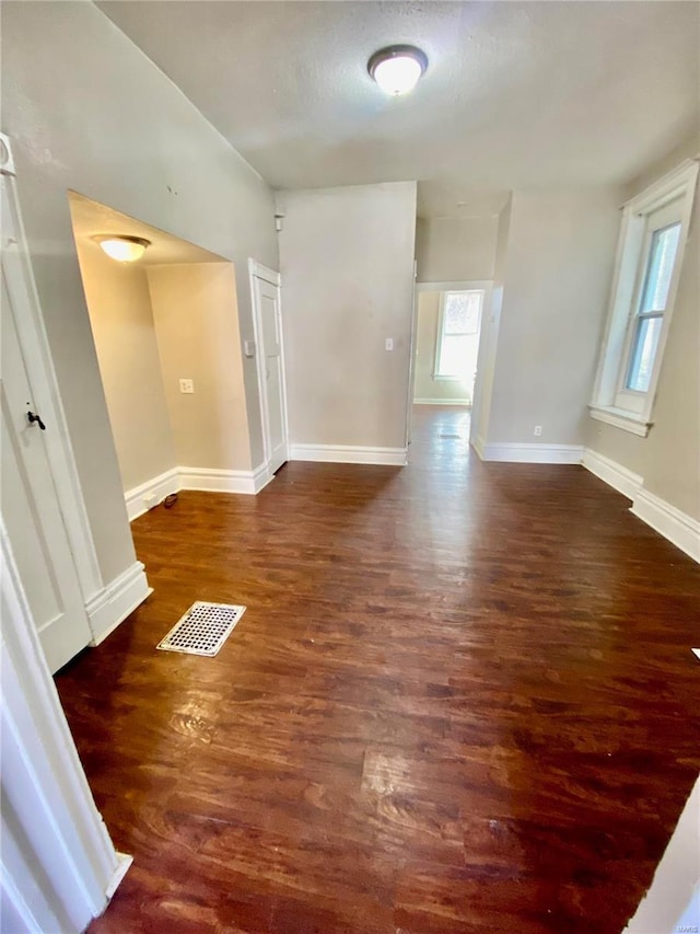 spare room featuring visible vents, baseboards, and wood finished floors