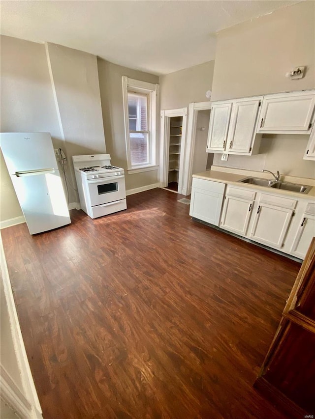 kitchen featuring white appliances, dark wood-style floors, a sink, light countertops, and white cabinetry