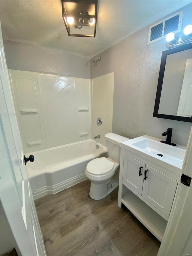 full bath with visible vents, wood finished floors, shower / bath combination, a textured wall, and vanity