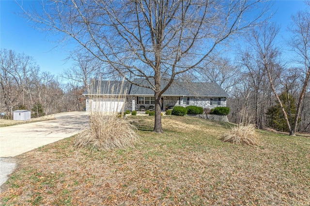 ranch-style house featuring a front yard, stone siding, a garage, and driveway