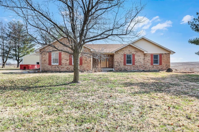 single story home featuring brick siding and a front yard