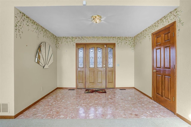 foyer featuring wallpapered walls, baseboards, and visible vents