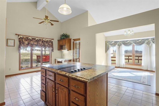 kitchen with black electric cooktop, beamed ceiling, light tile patterned flooring, and brown cabinetry