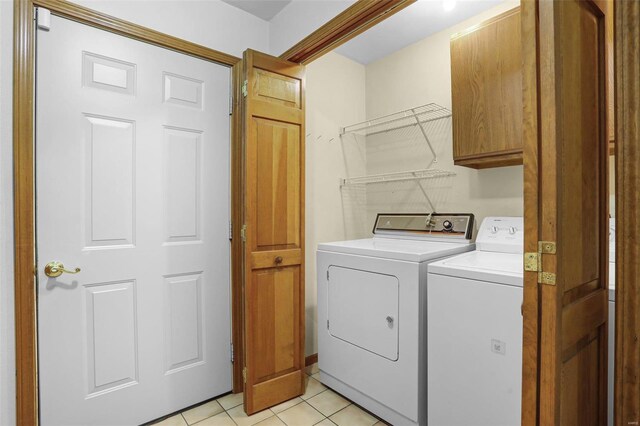 laundry room with light tile patterned floors, cabinet space, and independent washer and dryer