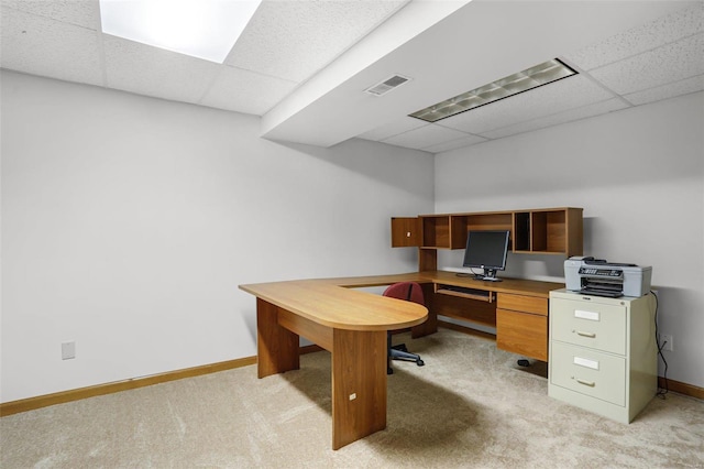 office with visible vents, light colored carpet, baseboards, and a drop ceiling