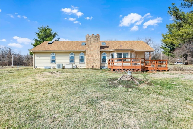 rear view of house featuring a wooden deck, central air condition unit, a chimney, and a yard