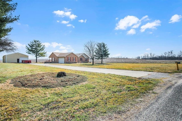 view of yard featuring driveway and a detached garage